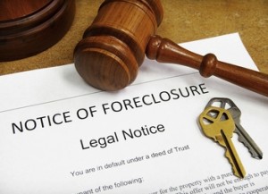Foreclosure document with house keys and gavel